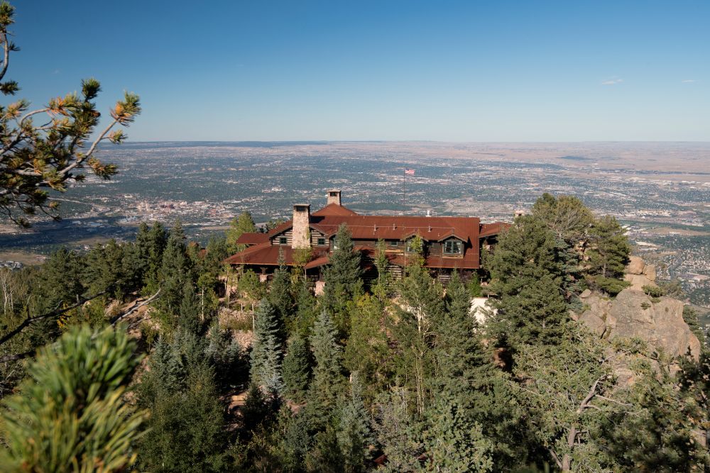 Main lodge of Cloud Camp, on the peak of a mountain with Colorado Springs in the background.