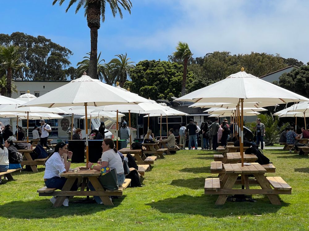 People sitting at picnic tables in Presidio of San Francisco.