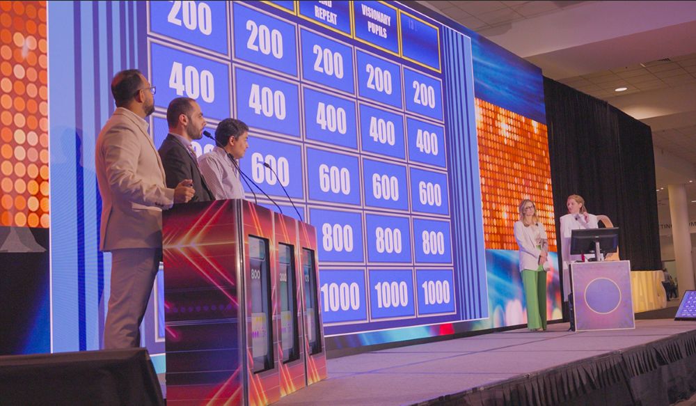 Photo of a Jeopardy!-style gameshow on stage at American Academy of Neurology annual meeting.