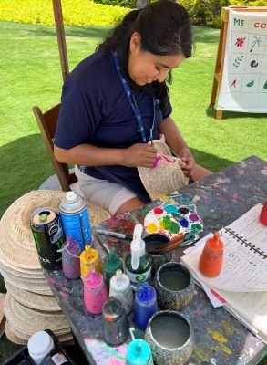 Artisan painting hats with designs of local artifacts at Unico 2087 in Riviera Maya, Mexico