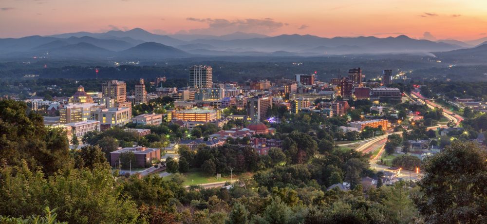 Aerial photo of downtown Asheville at dusk.
