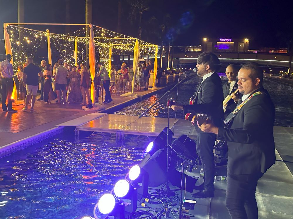 Attendees network at the opening reception while a Beatles cover band plays