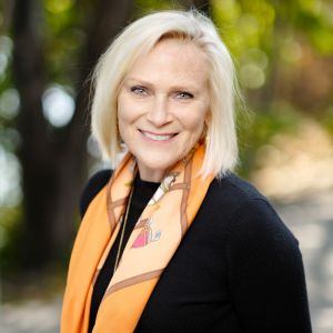 Photo of Becky Barrango in orange scarf and black shirt.