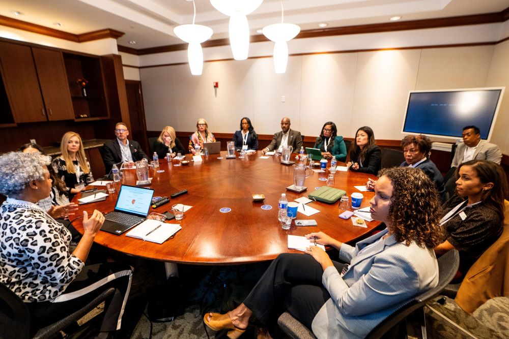 Photo of people around a round table at The Collective Experience.