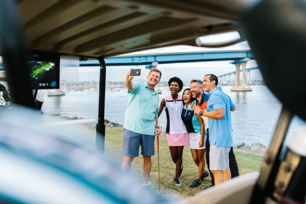 A group posing for a photo on a golf course.