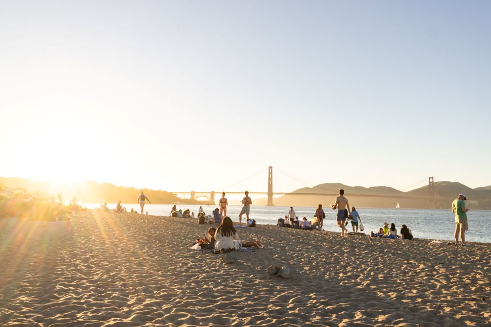 People enjoying Crissy Field Beach with the Golden Gate Bridge in the background.