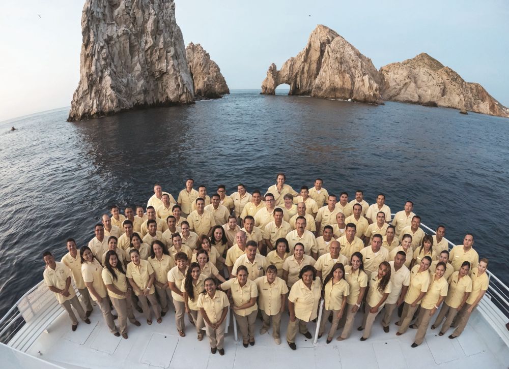 Photo of Terramar's Los Cabos staff standing on a boat in front of Los Arcos.