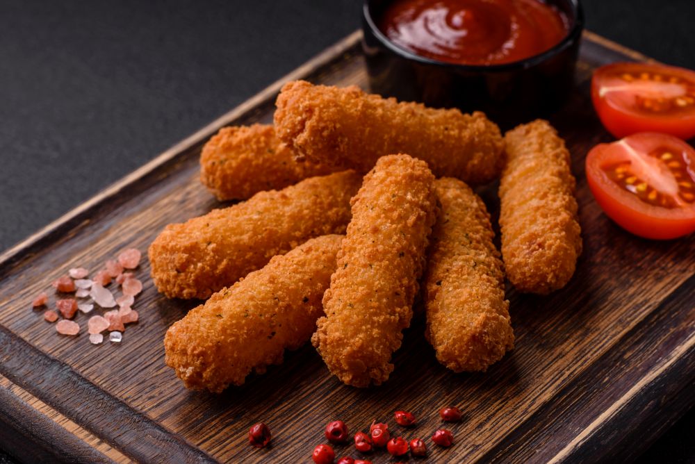 Photo of grilled cheese sticks with digging sauce and cut tomatoes.