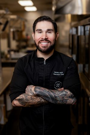 David Ruiz, standing in a kitchen with a black chef's uniform.