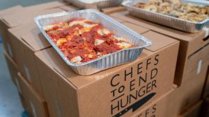Photo of a aluminum container full of lasagna on top of boxes.