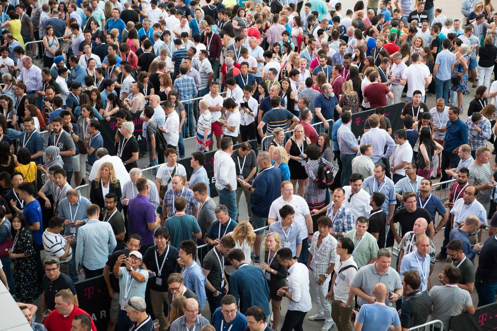 Photo of a mass of people entering a sports facility in a long, meandering line.