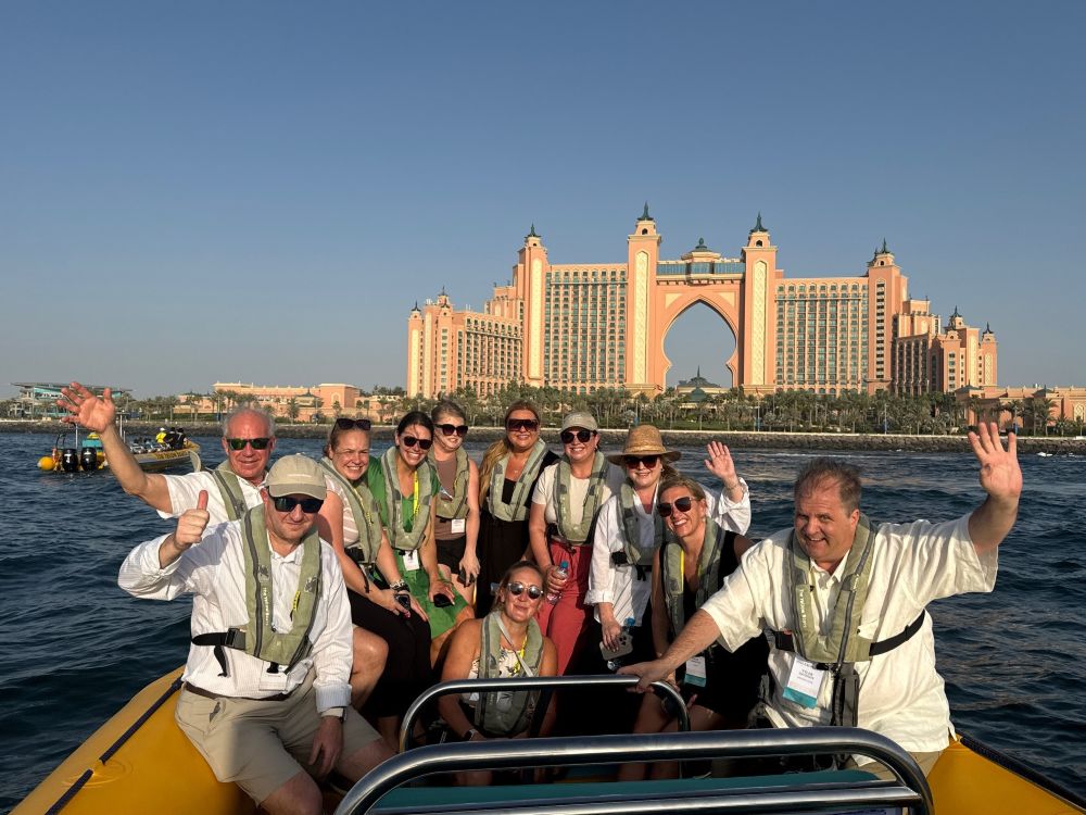 Photo of DMC Network Exchange attendees in a boat with Atlantis, The Palm in the background.