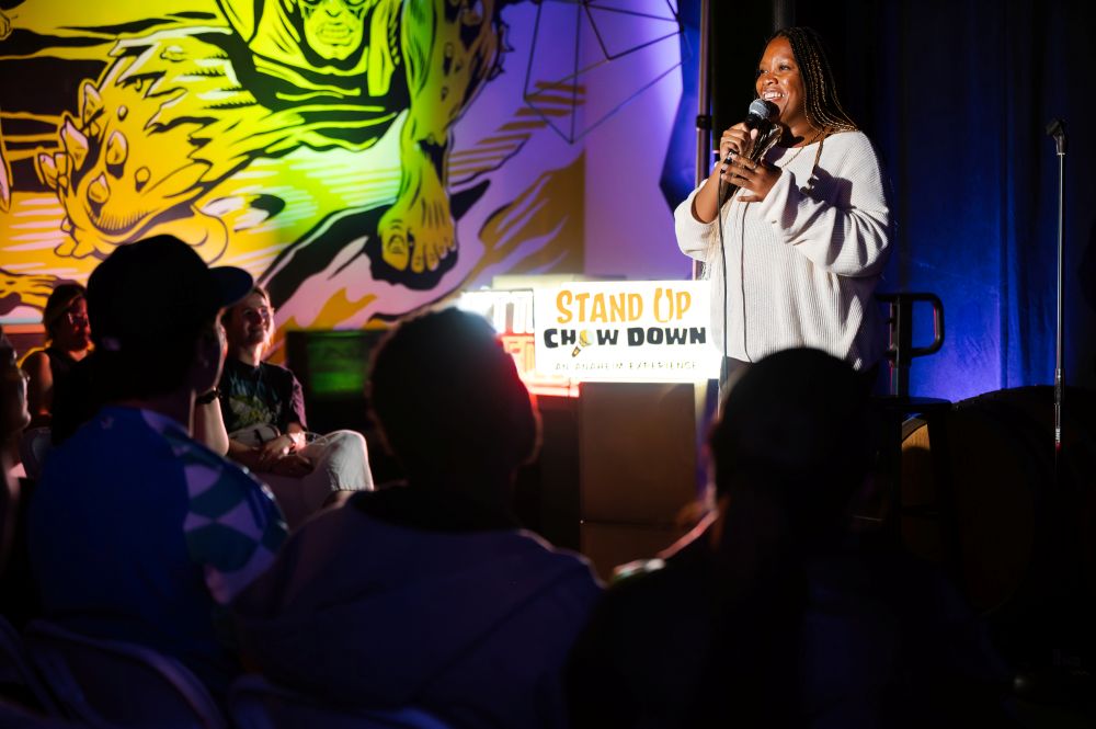 Photo of comedian on stage, at Stand Up, Chow Down festival.