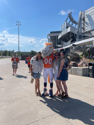 Attendees pose with Miles, the Denver Broncos mascot