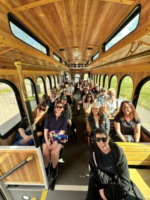 Group of people on a tour bus with lots of windows.
