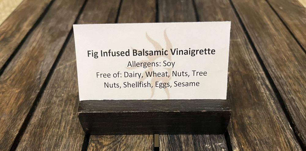 Photo of a food allergen card on a table, for fig infused viniagrette. 