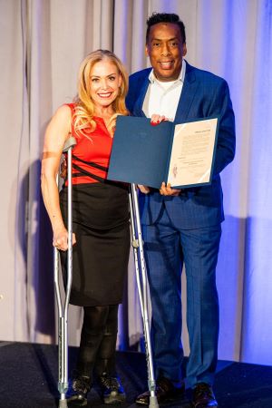 Photo of Greg DeShields on stage receiving a proclamation from the City of Philadelphia.