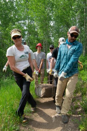 Group moving boulder during trail maintenance in Aspen area, Colorado