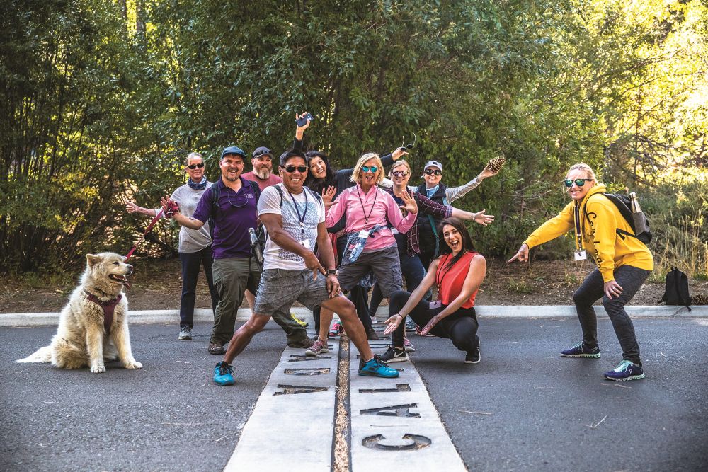 Photo of people straddling the state line of Nevada and California.
