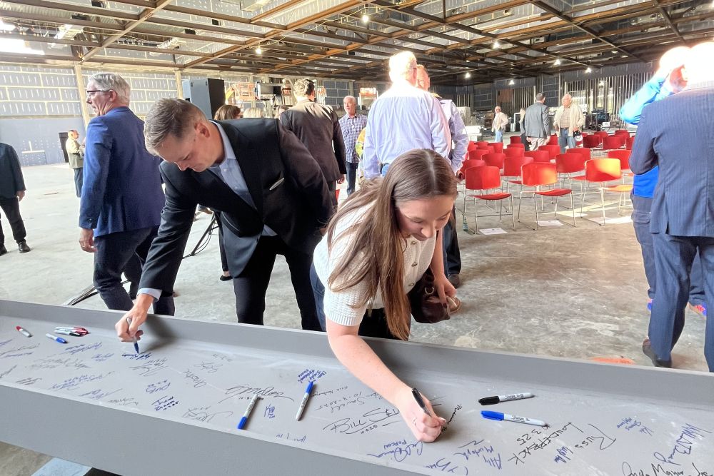 Meetings Today's Madeleine Willis signing the commemorative beam at the topping out ceremony.