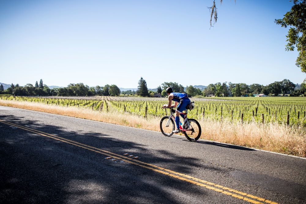 IRONMAN Cyclist Riding by vineyards in Santa Rosa
