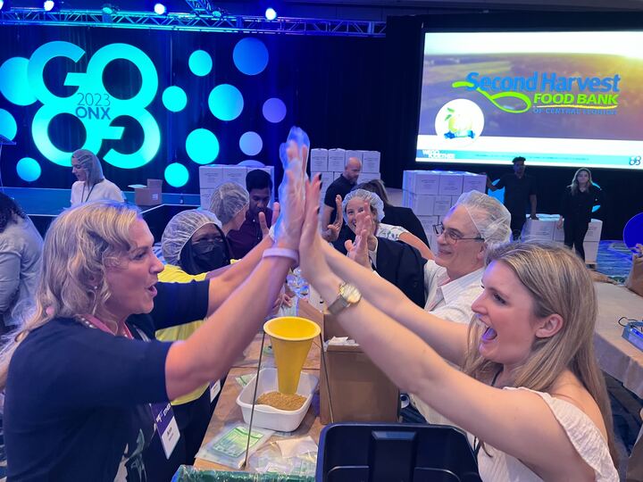 Two women giving each other high fives during a CSR event. 