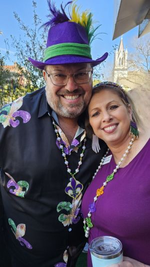Photo of Jason Ware (left) and Kelly Schulz (right) in mardi gras garb