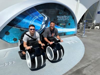 Jonathan Alder and a client pose in front of Disney's Tron ride