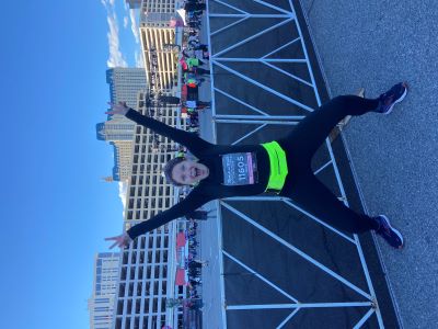 Photo of Kate Walsh, jumping in a running suit.