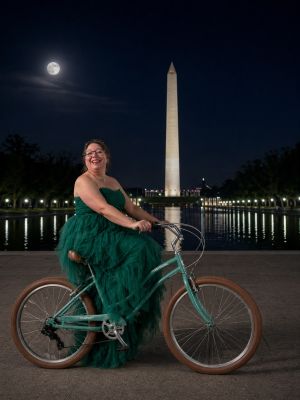 Melissa Katkó Pepin on a bicycle in front of the Washington Monument.
