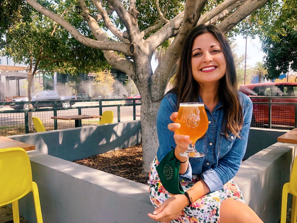 Megan Greenwood with beer in Greenwood Brewing outside area