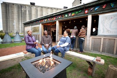 Attendees sit around a bonfire pit at an outdoor event in Buffalo, New York