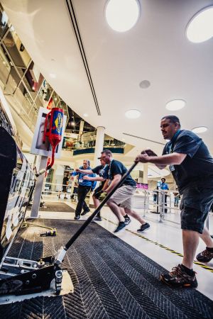 A man pushing a jack as part of the Pit Crew Challenge at the NASCAR Hall of Fame.