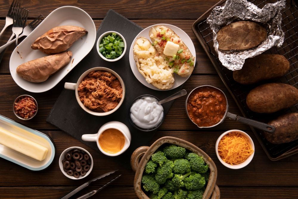 Photo of a potato bar with various small bowls with ingredients.