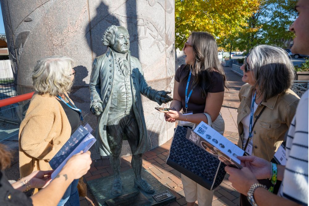 People standing around a statue of a president in Rapid City.