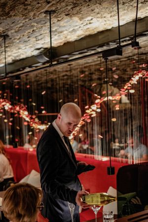 Photo of a server pouring wine at Taniere restaurant.