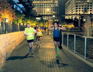 Photo of joggers running alongside a waterway.