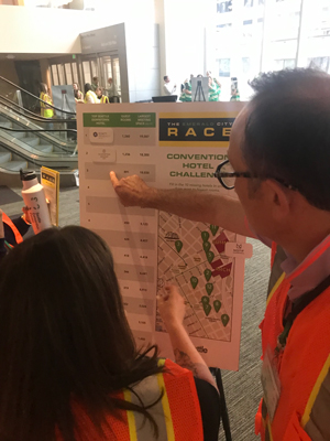 Photo of two people in reflective vests pointing to a placard inside of Seattle Convention Center.