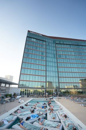 Photo of people floating on pads in a pool during a soundbath at Westin.