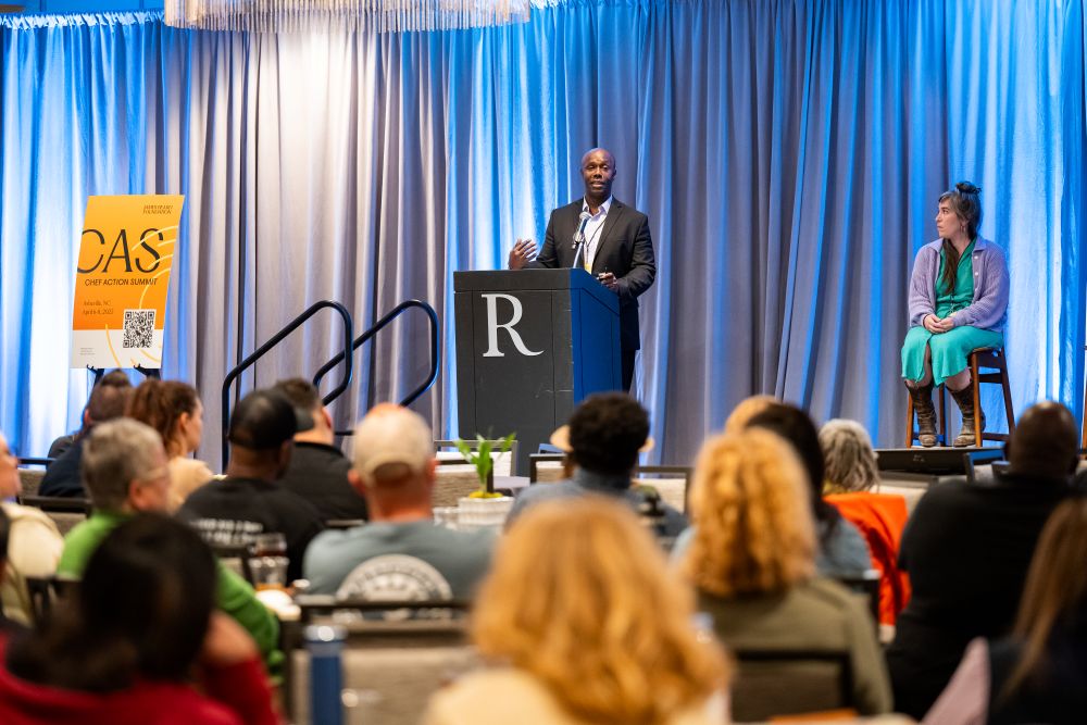 Ademola Oyefesco speaking in front of a crowd.