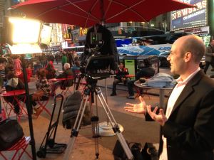 Photo of Scott Steinberg in front of media.