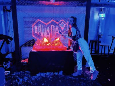 Taylor posing with an ice sculpture of Destination Canada's logo