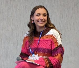 Photo of Taylor Smith in a multi-colored sweater.
