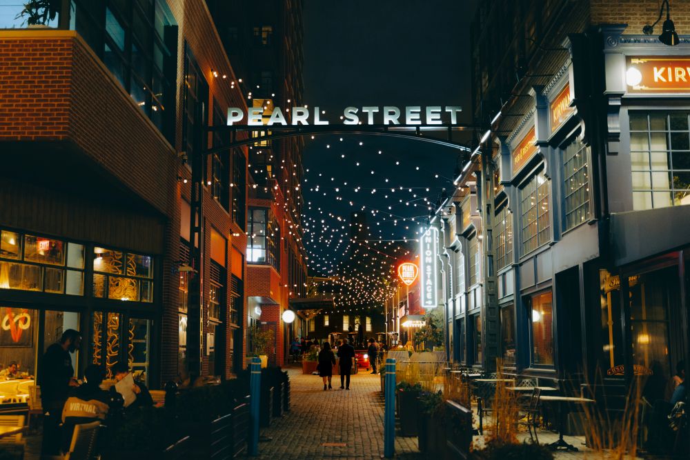 Image of nighttime at The Wharf District, with a Pearl Street sign over the street.