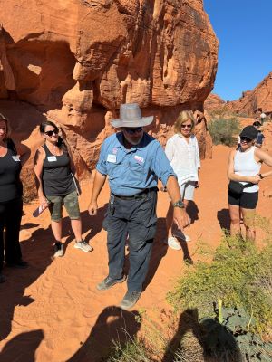 Pink Jeeps tour guide pointing to a desert plant in the Valley of Fire.