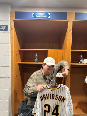 Photo of Tyler Davidson in Petco Park locker room, standing with jersey.