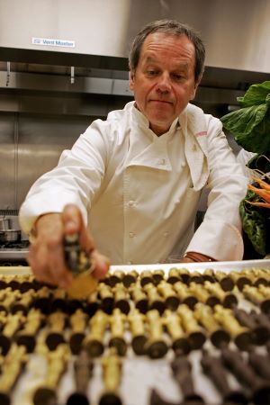 Photo of Wolfgang Puck organizing chocolate Oscars statuettes.