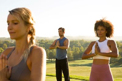 Three individuals doing yoga.