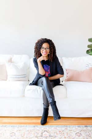 Photo of Dr. Brandi Baldwin, sitting on a couch.