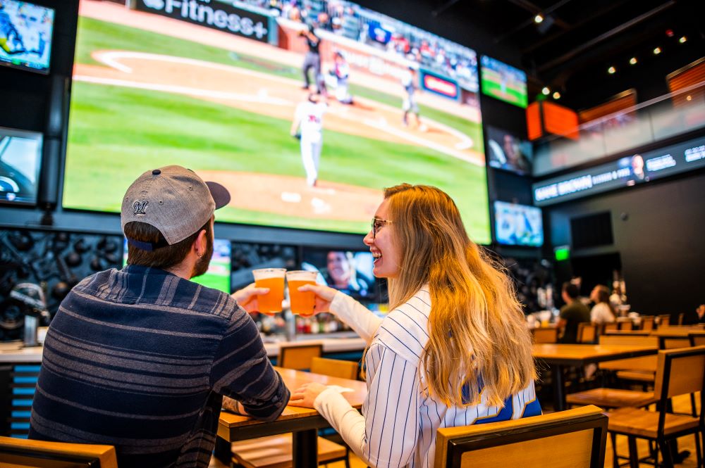 Two people watching baseball inside MECCA